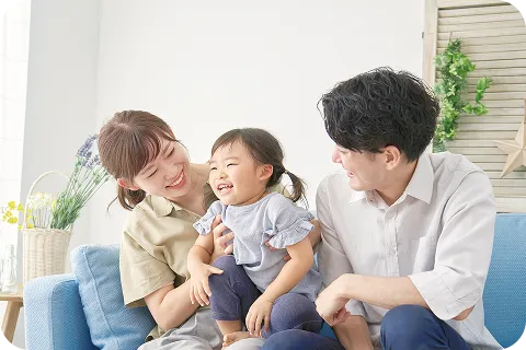 ソファで笑顔を交わす親子3人